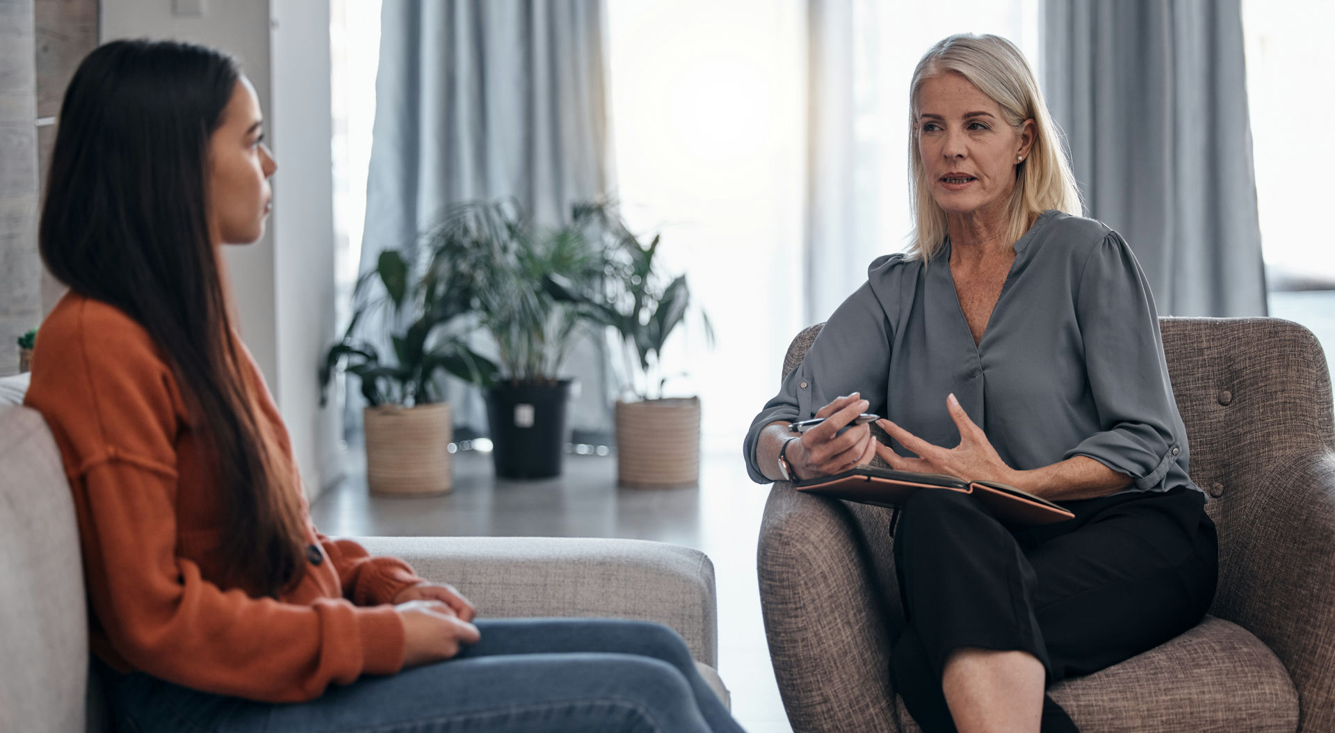 Therapist with clipboard explaining concepts while in individual therapy session