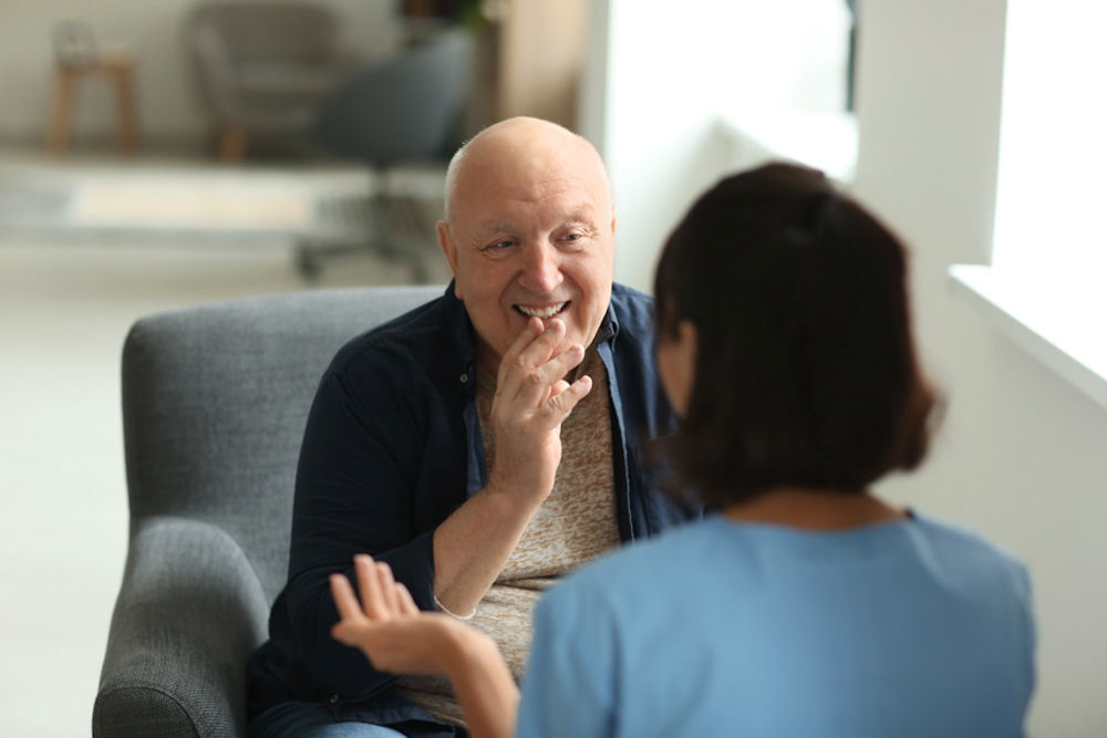 Older man learning about EMDR for addiction treatment from younger woman.