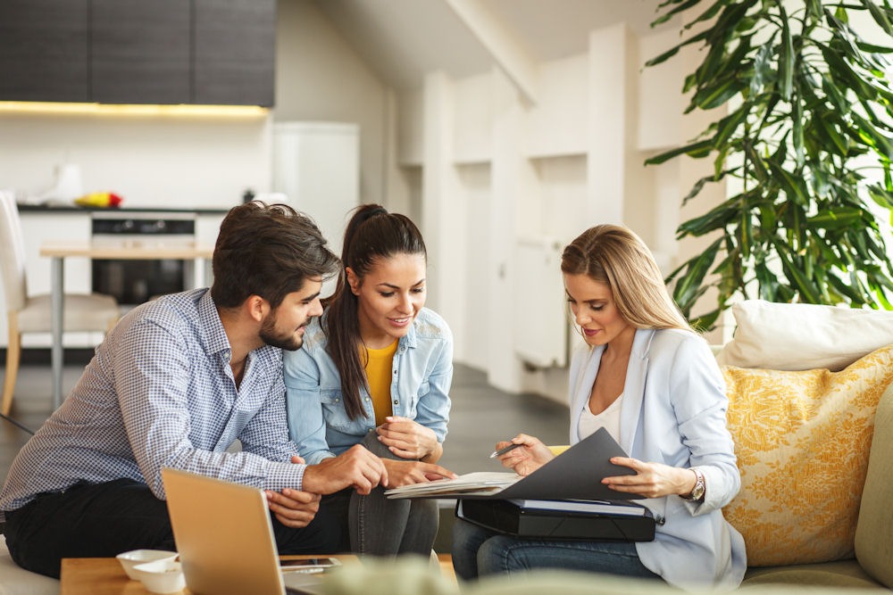 Young couple discussing insurance for rehab treatment options with an advisor at home