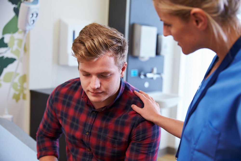 Nurse reassures young man with prescription drug addiction.