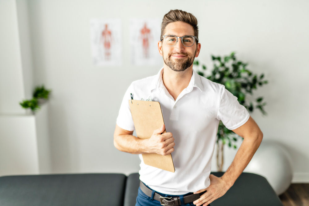 Man with glasses and folder ready to welcome college students to addiction treatment.