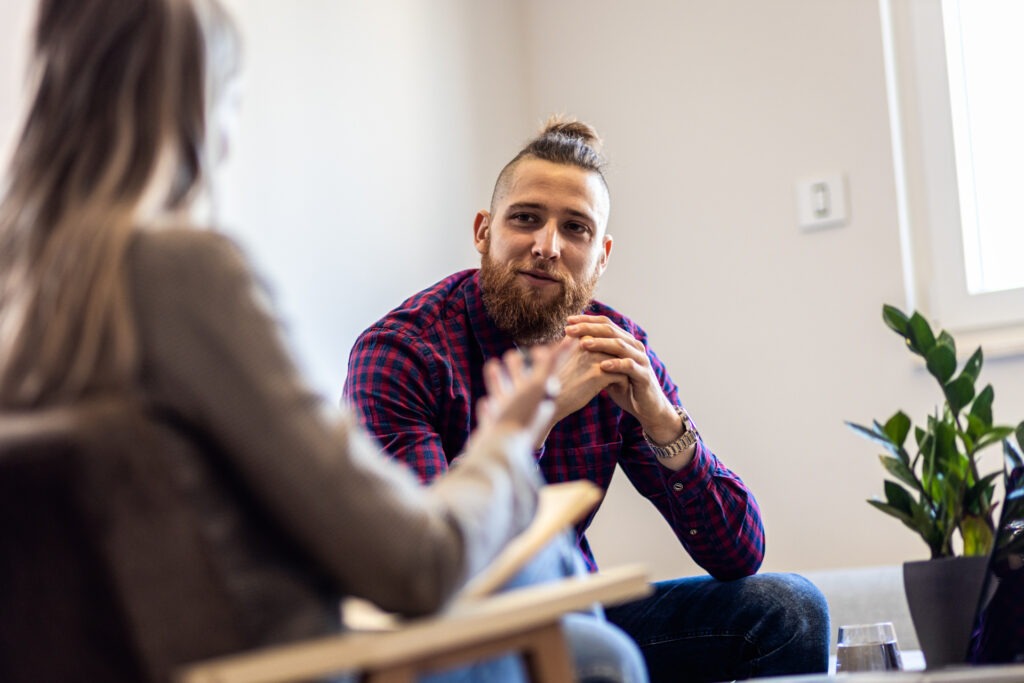 Man listens to a counselor talk during individual therapy for addictions.