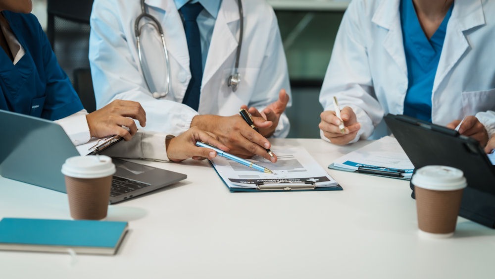 Group of doctors discussing bipolar diagnoses at table.