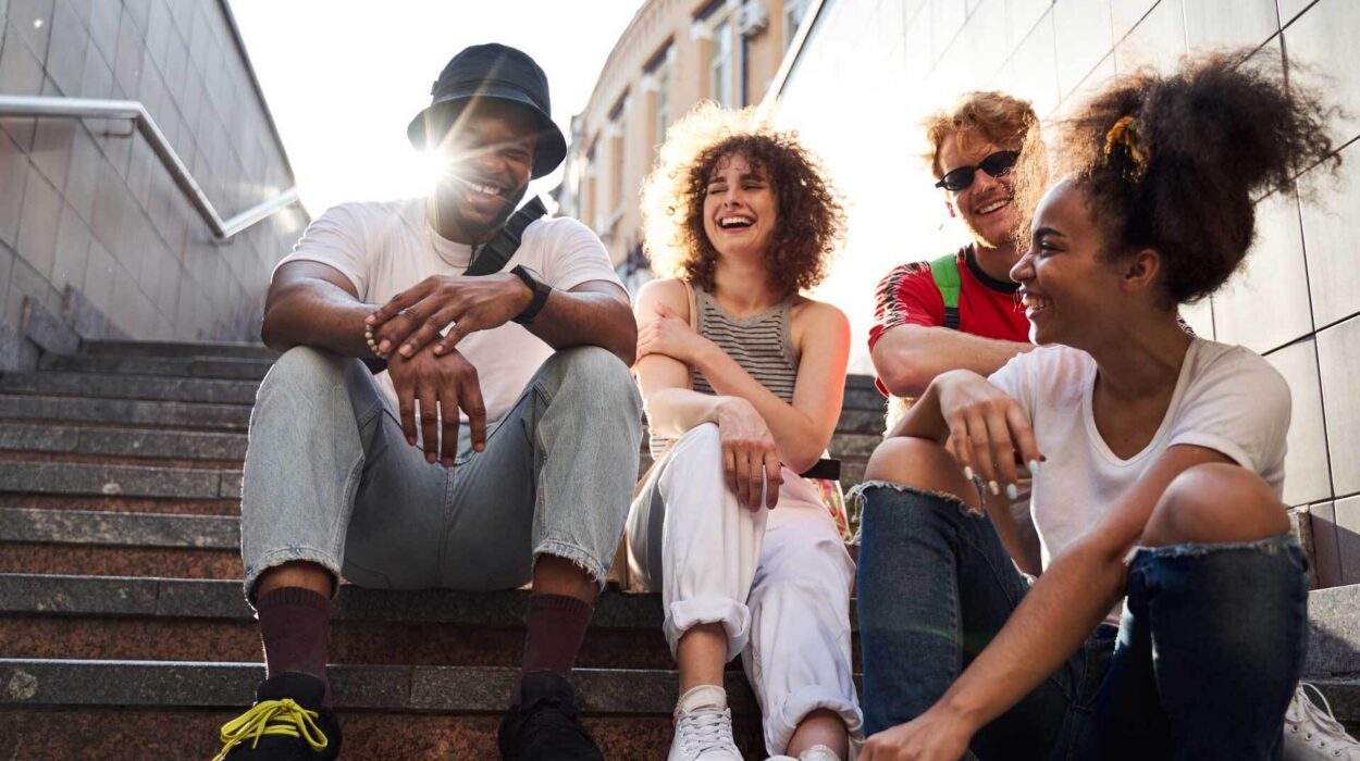 Group of teens laughing while sitting on stoop