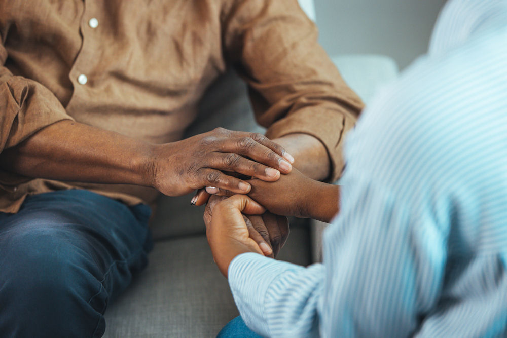 Close shot of man patting a woman's hand