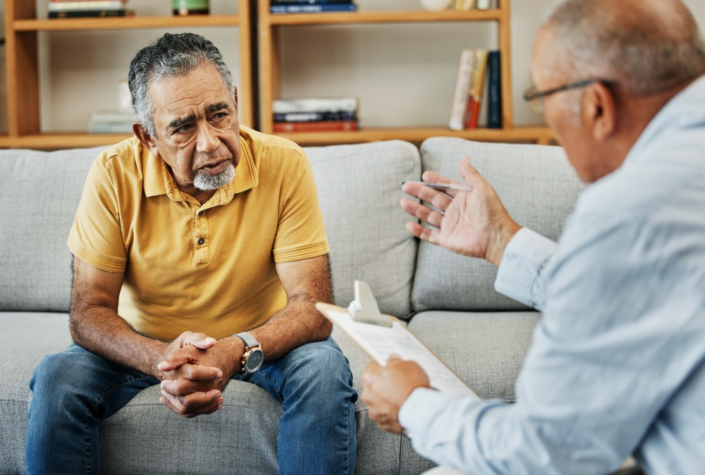 Therapist explaining schizophrenia to older gentleman