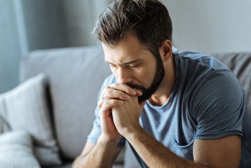 male veteran struggling with PTSD and addiction looking down sad